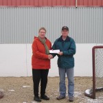 Pinawa Foundation Board Member Carol Findlay presents $1000 to Chris Elcock, Orville Acres Arena Board Chair