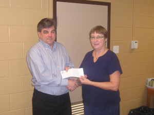 Pinawa Foundation Board Member C. Findlay presents a $2337 cheque to Mayor Skinner for the Legacy Park Project